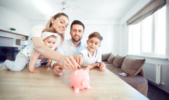 A Smiling Family Saves Money With A Piggy Bank.